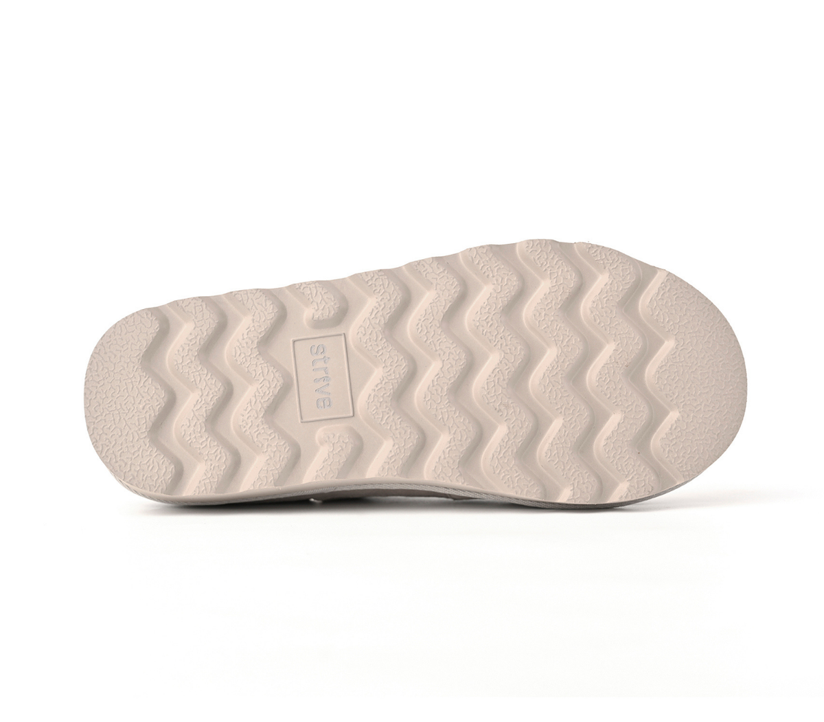 The textured bottom sole of a slip-on shoe in a light beige or cream color, featuring a wavy tread pattern and a small embossed brand label reading 'STRIVE'.