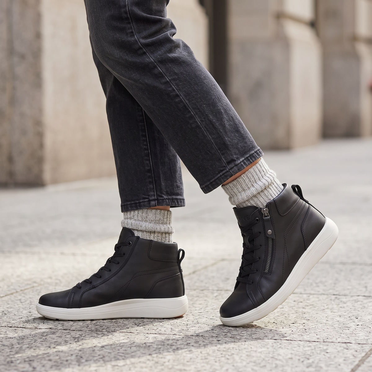Black Strive Mayfair ankle boots with dual side zips worn outdoors