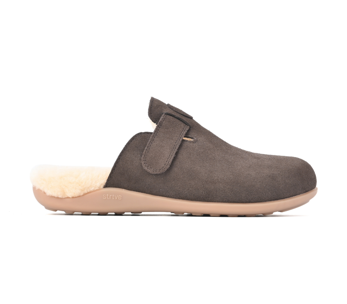 A single dark brown suede clog-style slipper with a light beige sole and a cream-colored shearling lining, shown in profile against a white background. Strive Footwear Oslo II Women’s Brown Slippers