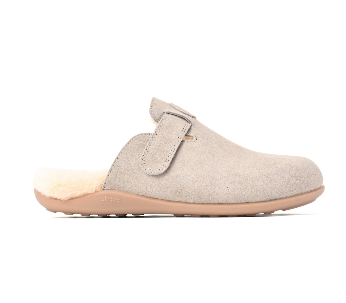 A light beige suede clog slipper with a soft cream shearling lining and a tan sole, shown in a side profile on a white background. Strive Footwear Oslo II Women’s Grey Slippers