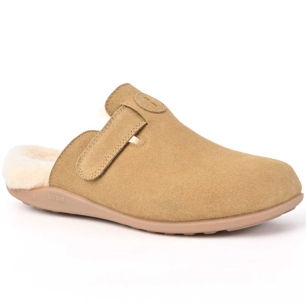 A tan suede clog-style slipper with a soft cream shearling lining and a tan sole, shown from a side profile on a white background. Strive Footwear Oslo II Women’s Tan Slippers