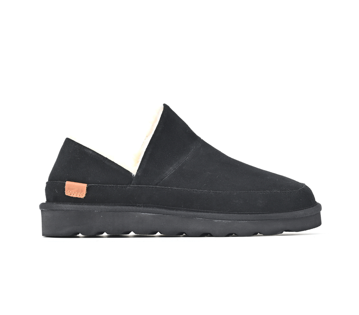 A black slip-on slipper with a thick black sole and a small tan leather brand tab on the heel, shown from a side profile on a white background.  Strive Footwear Women’s Alaska Black Slippers