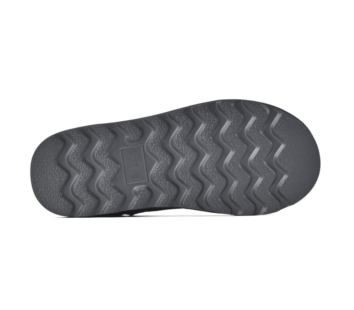 A close-up view of a dark grey shoe sole with a wavy tread pattern, shown against a plain white background.  Strive Footwear Women’s Alaska Black Slippers