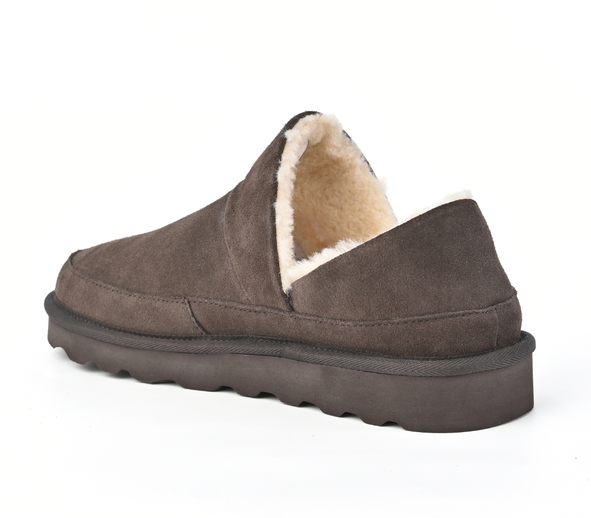 A single slip-on slipper shoe in dark brown suede with a cream-coloured shearling lining, shown from a three-quarters angle on a white background. Strive Footwear Women’s Alaska Brown Slippers