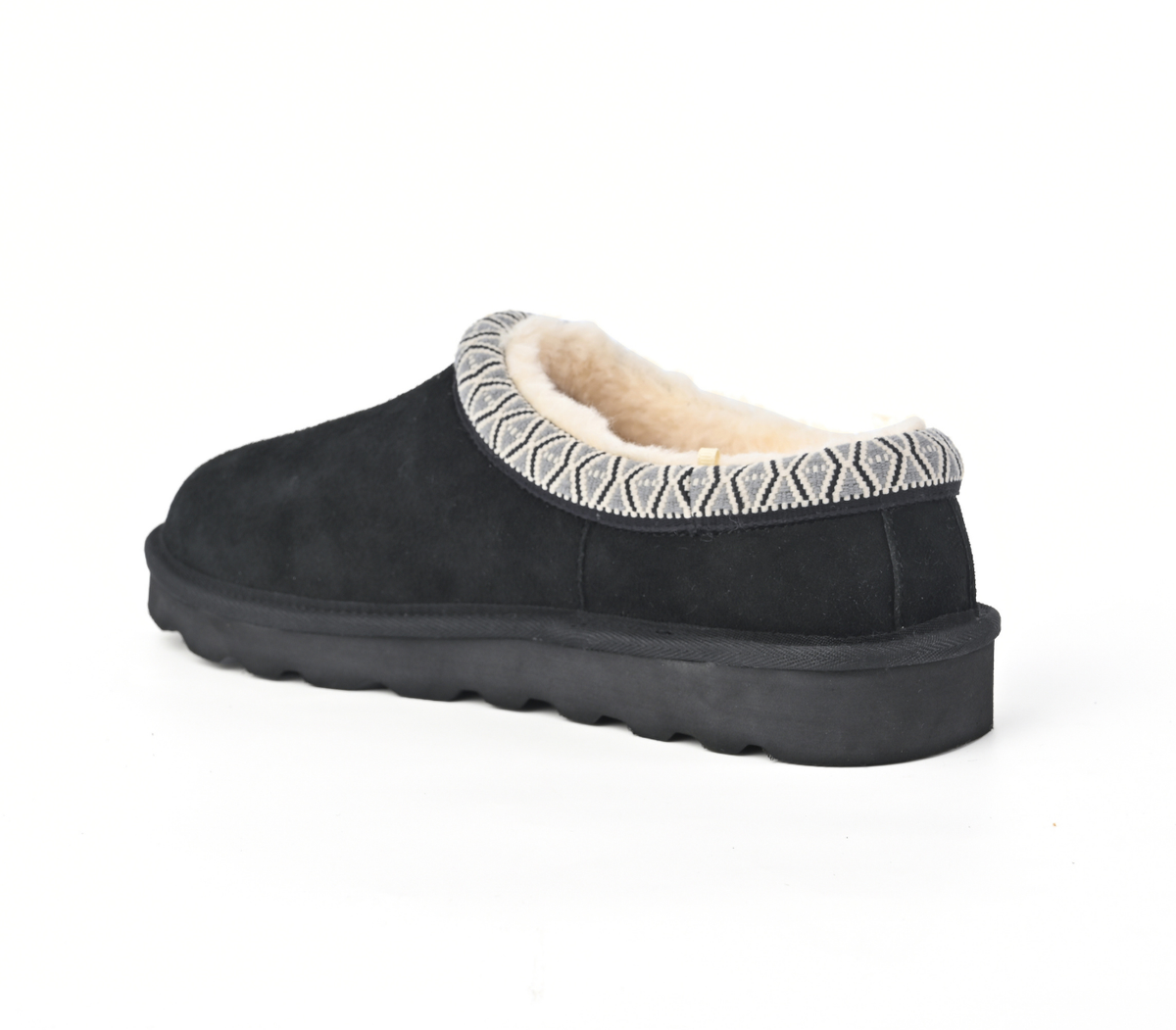 A single black slip-on clog-style slipper with a soft cream shearling lining and a patterned knit trim around the collar, shown from a side angle on a white background.